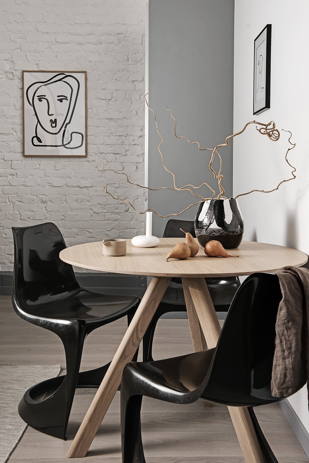 Okrągły drewniany stolik z czarnymi krzesłami